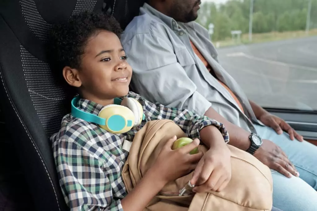 image of a young black child holding on to his schoolbag with neoprene as its backpack material